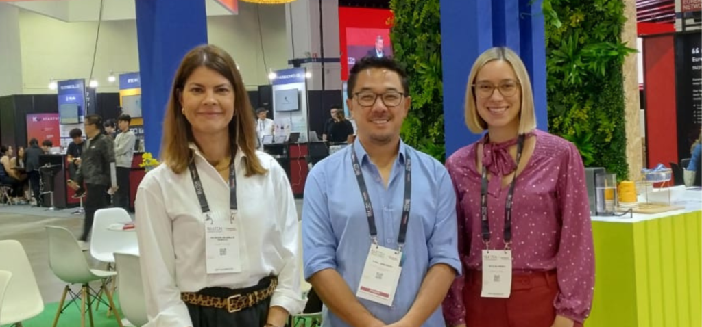 As quatro mulheres da comitiva da Inova Unicamp posam em frente a Usina Hidrelétrica de Itaipu. Da esquerda para a direita, Raphaela Gomes, Mariana Zanatta Inglez, Luciana Silva e Kátia Kishi. Fim da descrição.